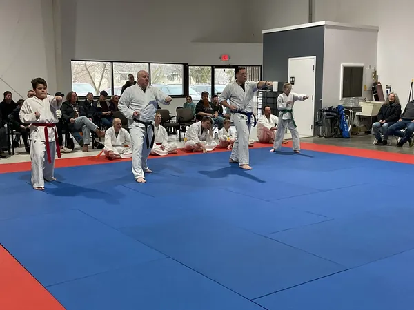 Adults and instructors practicing forms together on the mats
